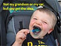 Child eating lollipop in carseat