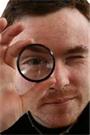 Title: man looking through magnifier